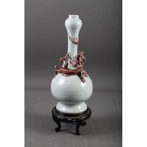 61 - A Chinese pale glazed bottle neck vase with relief iron oxide coloured dragon decoration, 11 3/4