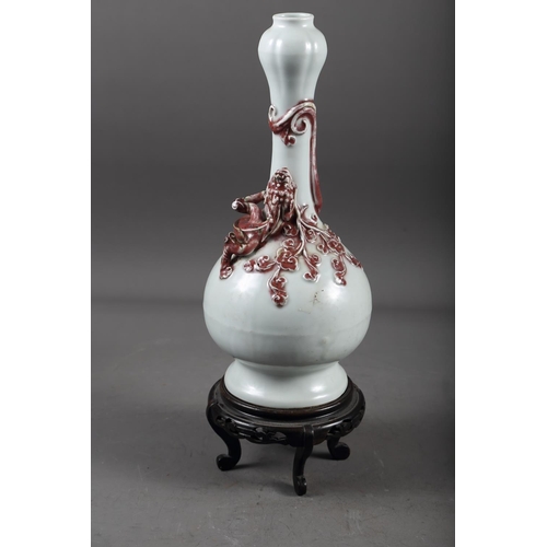 61 - A Chinese pale glazed bottle neck vase with relief iron oxide coloured dragon decoration, 11 3/4