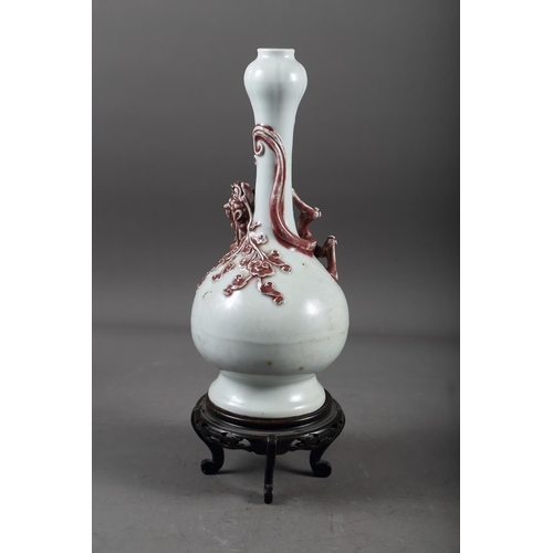 61 - A Chinese pale glazed bottle neck vase with relief iron oxide coloured dragon decoration, 11 3/4