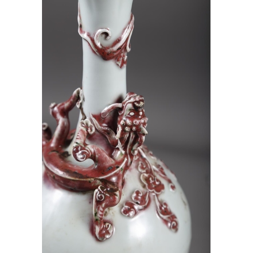 61 - A Chinese pale glazed bottle neck vase with relief iron oxide coloured dragon decoration, 11 3/4