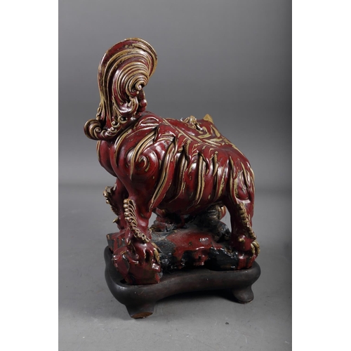 62 - A Chinese red and brown glazed porcelain model of a Dog of Fo, on hardwood stand, 16