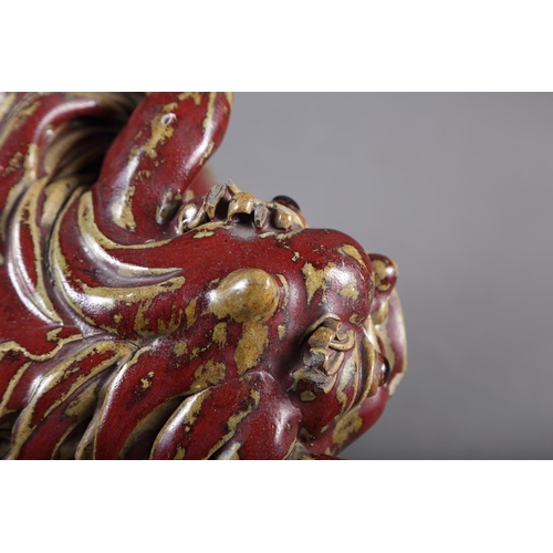 62 - A Chinese red and brown glazed porcelain model of a Dog of Fo, on hardwood stand, 16