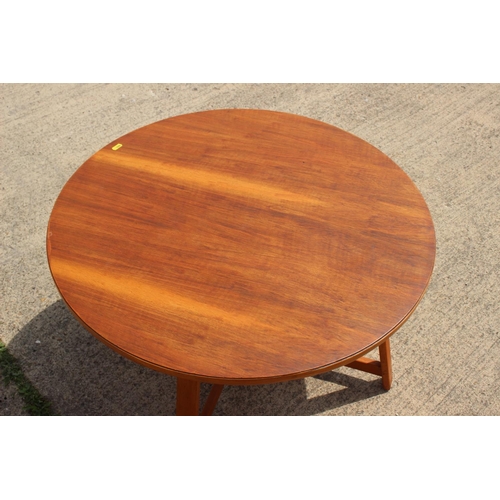 670 - A 1960s teak circular top occasional table, on splay supports, 30