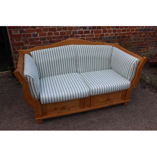 681 - A waxed pine two-seat showframe settee, fitted two drawers and loose cushions, on bun feet, 52