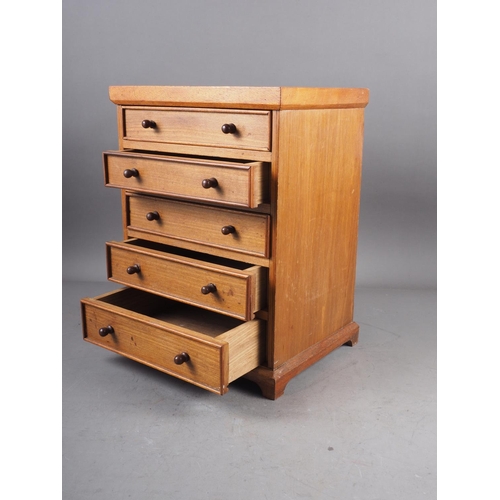 123 - A mahogany miniature chest of five long graduated draws, on bracket feet, 11