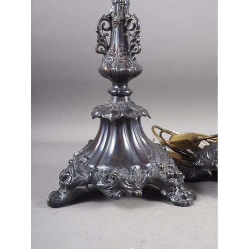 178 - A pair of bronzed table lamps with scroll and flower design, on triform base, 22