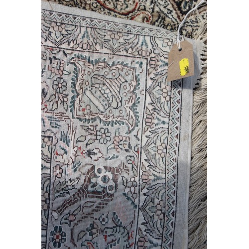 704 - A Kerman silken pile rug with all-over scroll and vase design on a light ground, 72