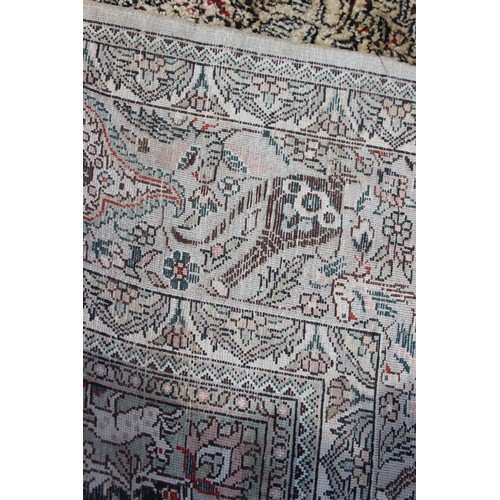 704 - A Kerman silken pile rug with all-over scroll and vase design on a light ground, 72