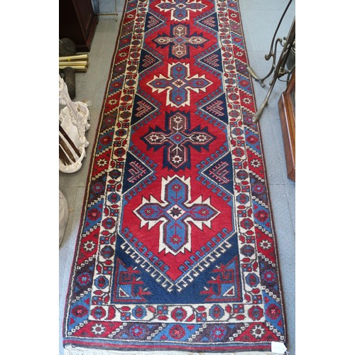 701 - A pair of Kazak wool runners with ten central medallions, in shades of red, blue and natural, 35