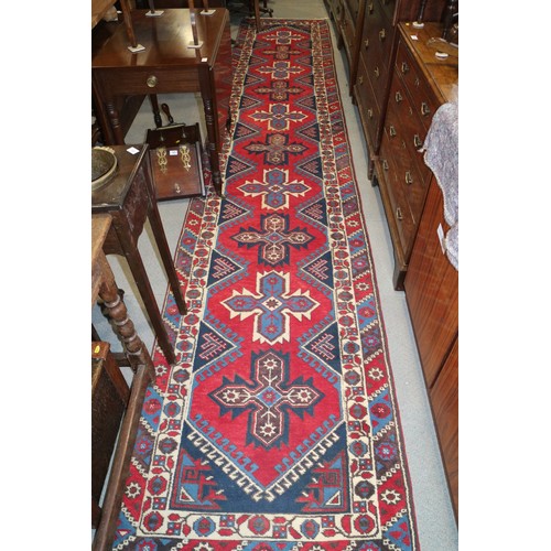 701 - A pair of Kazak wool runners with ten central medallions, in shades of red, blue and natural, 35