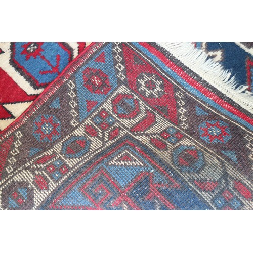 701 - A pair of Kazak wool runners with ten central medallions, in shades of red, blue and natural, 35