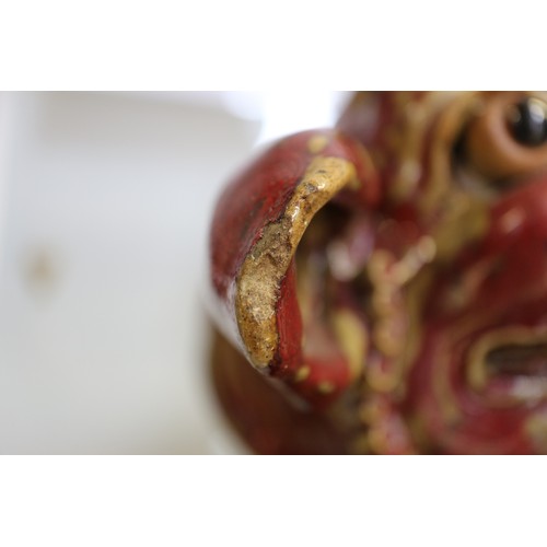 62 - A Chinese red and brown glazed porcelain model of a Dog of Fo, on hardwood stand, 16