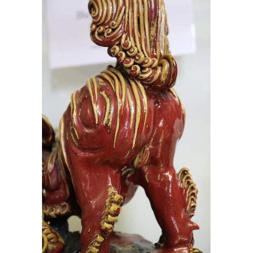 62 - A Chinese red and brown glazed porcelain model of a Dog of Fo, on hardwood stand, 16