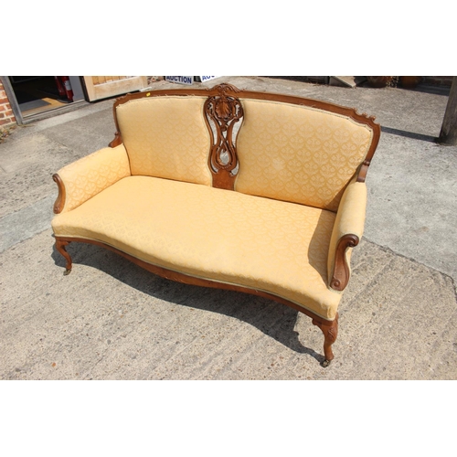 463 - A French walnut showframe settee with carved and pierced central splat, upholstered in a patterned y... 