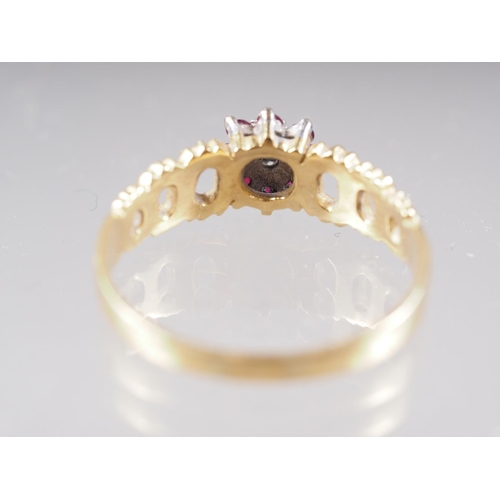 351 - A yellow metal dress ring, stamped 18ct, cluster set diamond and rubies, size U