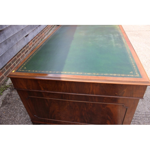 500 - A partners walnut double pedestal desk with green tooled leather lined top, fitted cupboards and dra... 