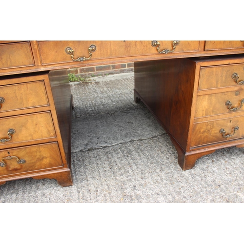 500 - A partners walnut double pedestal desk with green tooled leather lined top, fitted cupboards and dra... 