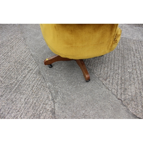 522 - A 1930s revolving office chair, upholstered in an old gold fabric, on castored supports