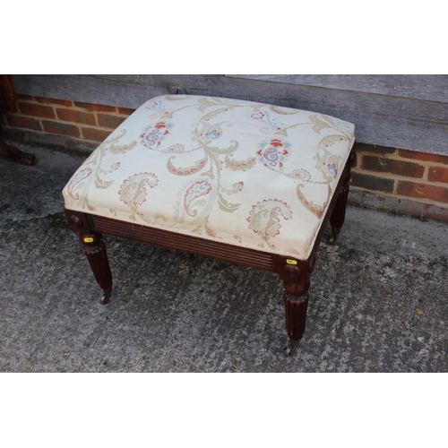 543 - A mahogany centre stool of Regency design with brocade seat, on turned reeded and castored supports