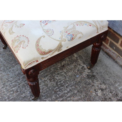 543 - A mahogany centre stool of Regency design with brocade seat, on turned reeded and castored supports