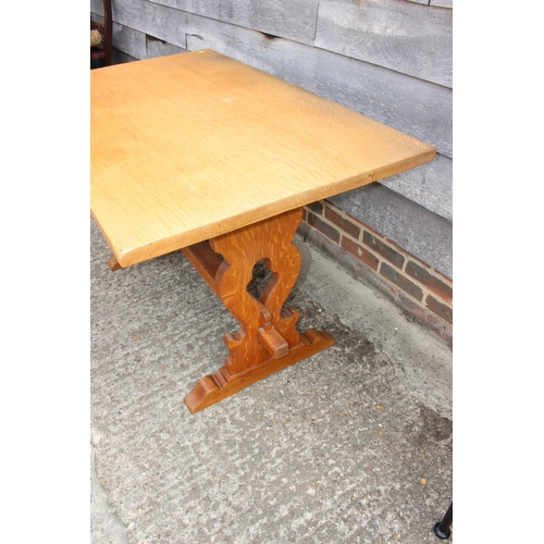 569 - A light oak refectory table, on pierced panel end stretchered supports, 48