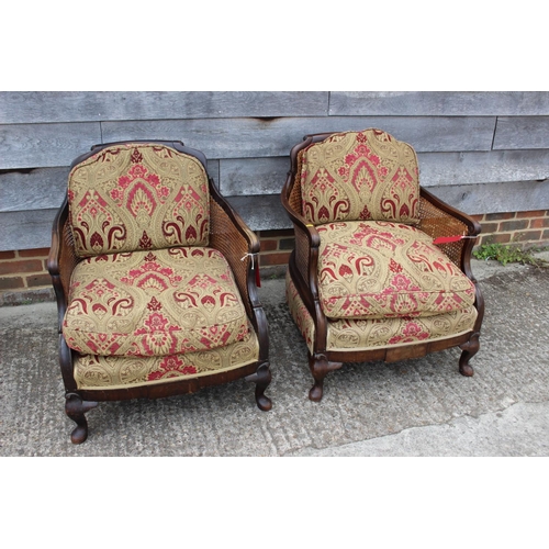 589 - An early 20th century carved mahogany bergere three-piece suite with loose seat cushions, on cabriol... 