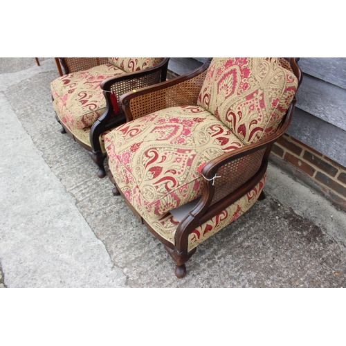 589 - An early 20th century carved mahogany bergere three-piece suite with loose seat cushions, on cabriol... 