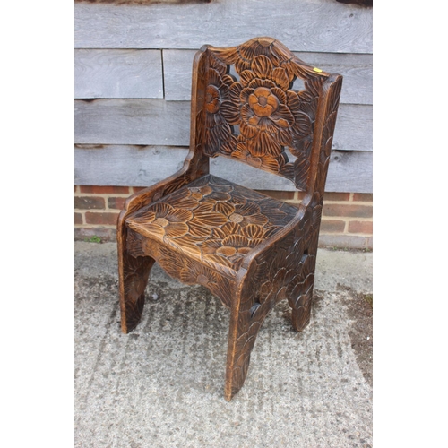 595 - A Liberty's style early 20th century carved hardwood chair with panel seat, 37 1/2