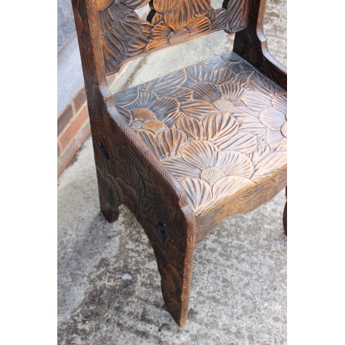 595 - A Liberty's style early 20th century carved hardwood chair with panel seat, 37 1/2