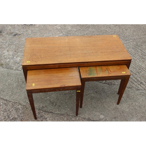 596 - A nest of three 1960s teak tables, on square taper supports, largest 33