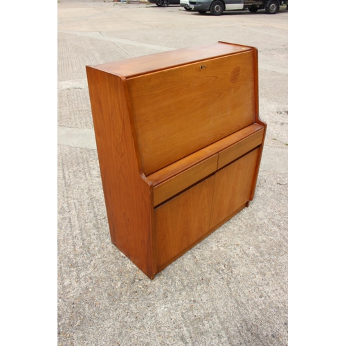 597 - A 1960s teak fall front bureau with fitted interior over two drawers and cupboards, 36