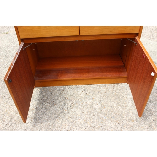 597 - A 1960s teak fall front bureau with fitted interior over two drawers and cupboards, 36