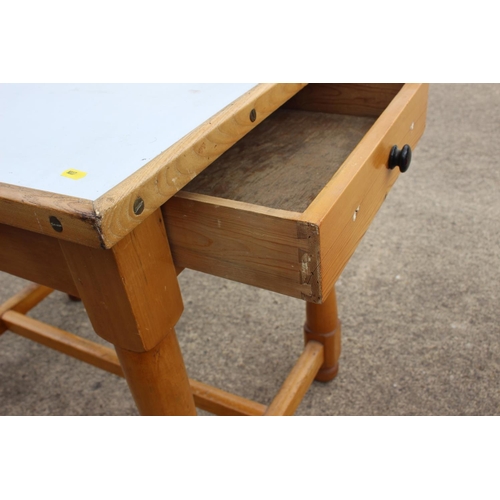 615 - A varnished pine kitchen table with white metal top, on turned and stretchered supports, 37