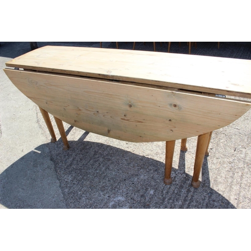 616 - A 19th century scrub top oval drop leaf kitchen table, on turned and tapered supports and pad feet, ... 