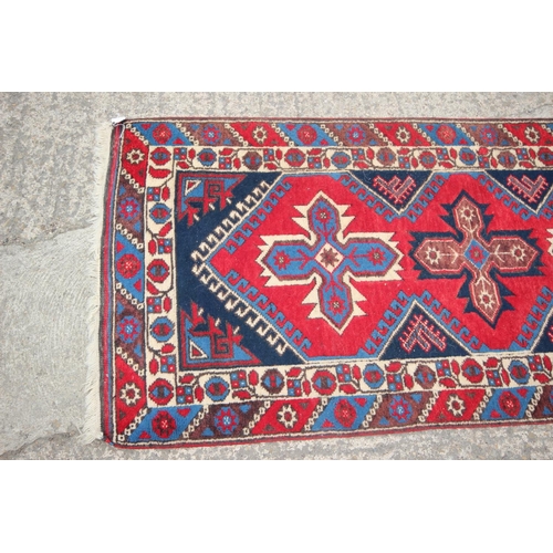 622 - A pair of Kazak wool runners with ten central medallions, in shades of red, blue and natural, 35