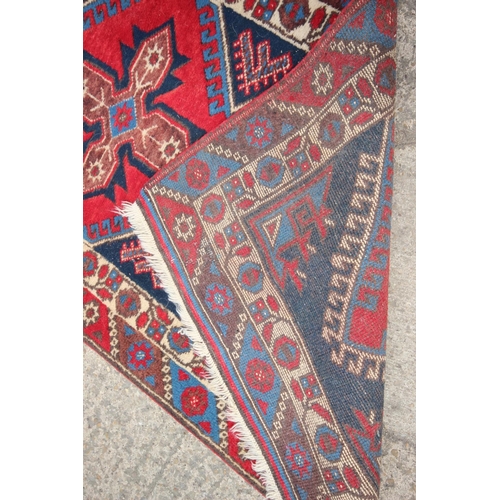 622 - A pair of Kazak wool runners with ten central medallions, in shades of red, blue and natural, 35