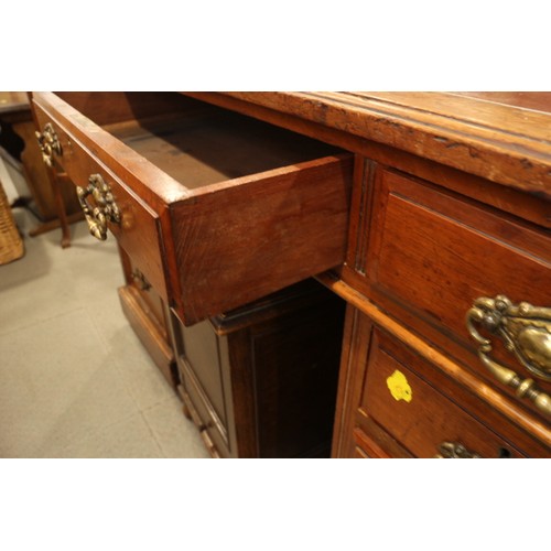 608 - An early 20th century walnut double pedestal desk, fitted nine drawers with brass handles, on bracke... 