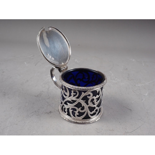 291 - A Victorian silver mustard pot with pierced and scrolled decoration, and blue glass liner, 3.2oz tro... 