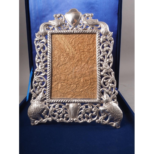 307 - An Indian white metal easel photograph frame, decorated elephants and peacocks, stamped silver, in f... 