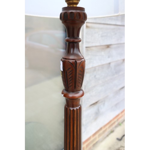 204 - A carved mahogany standard lamp, on circular base