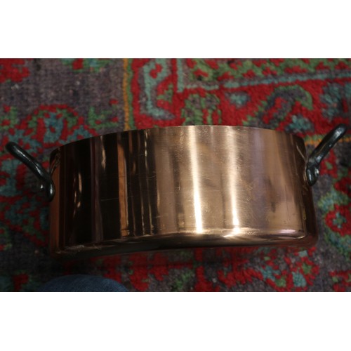 125 - Three copper and iron handled saucepans, two similar frying pans, a tureen and a hanging rack