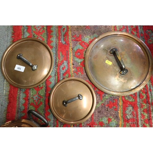 125 - Three copper and iron handled saucepans, two similar frying pans, a tureen and a hanging rack