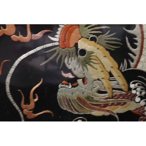 523 - *An early 20th century mahogany framed firescreen with dragon embroidered silk panel, 23 1/2