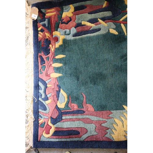 623 - A 1930s style Chinese contour pile rug with stylised bamboo, rocks and prunus tree design on a green... 