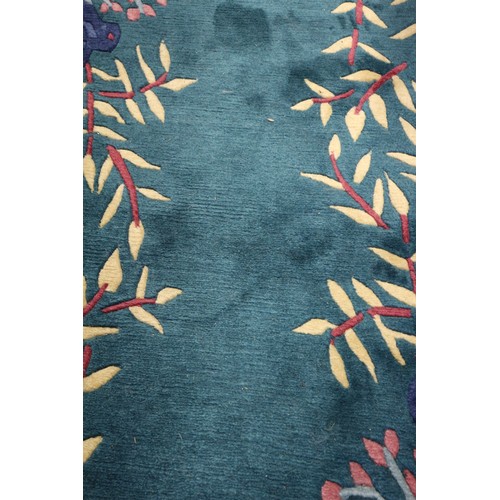 623 - A 1930s style Chinese contour pile rug with stylised bamboo, rocks and prunus tree design on a green... 