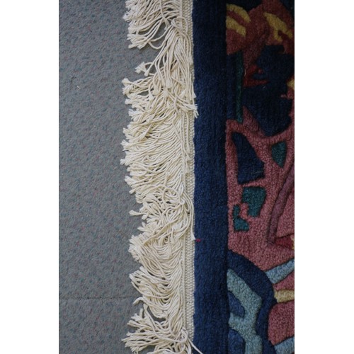 623 - A 1930s style Chinese contour pile rug with stylised bamboo, rocks and prunus tree design on a green... 