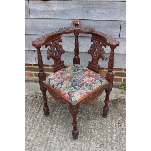 560 - A 19th century carved mahogany corner elbow chair with griffin splats and drop-in seat, on turned su... 