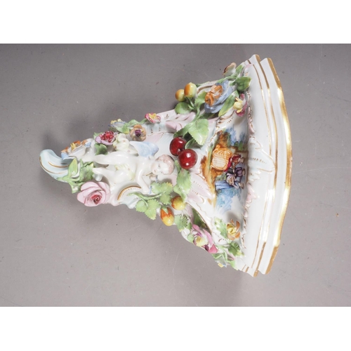 17 - A contemporary German porcelain wall bracket with relief flower and cherub decoration, 7 3/4