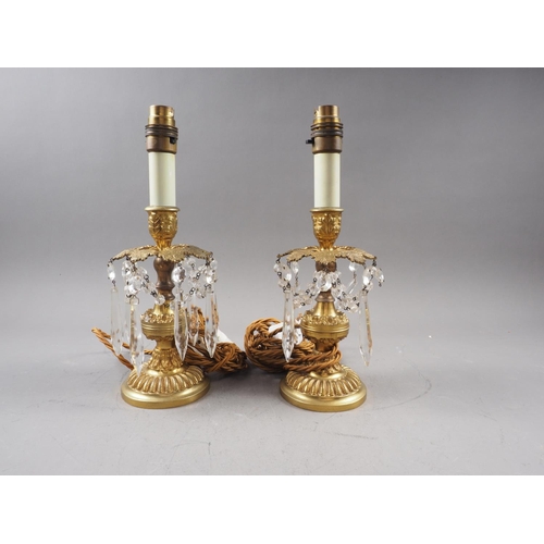 262 - A pair of brass table lustres with relief leaf decoration and glass spearpoint drops, 11 1/2