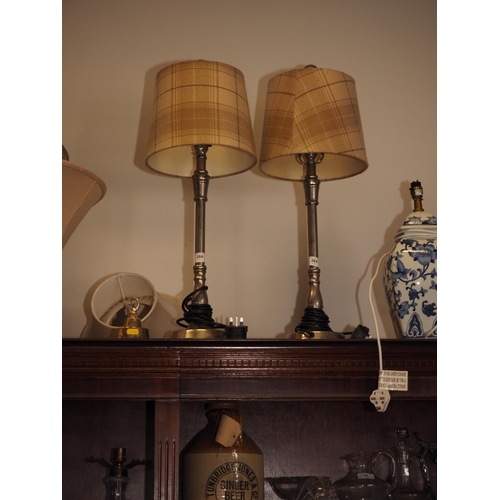 264 - A pair of turned steel table lamps, on circular bases, 18 1/2